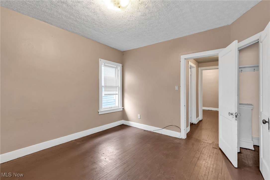 3770 Mayfield Road Cleveland Heights, OH 44121 - Photo 8 of 22 Unfurnished bedroom featuring dark hardwood / wood-style flooring, a textured ceiling, and a closet