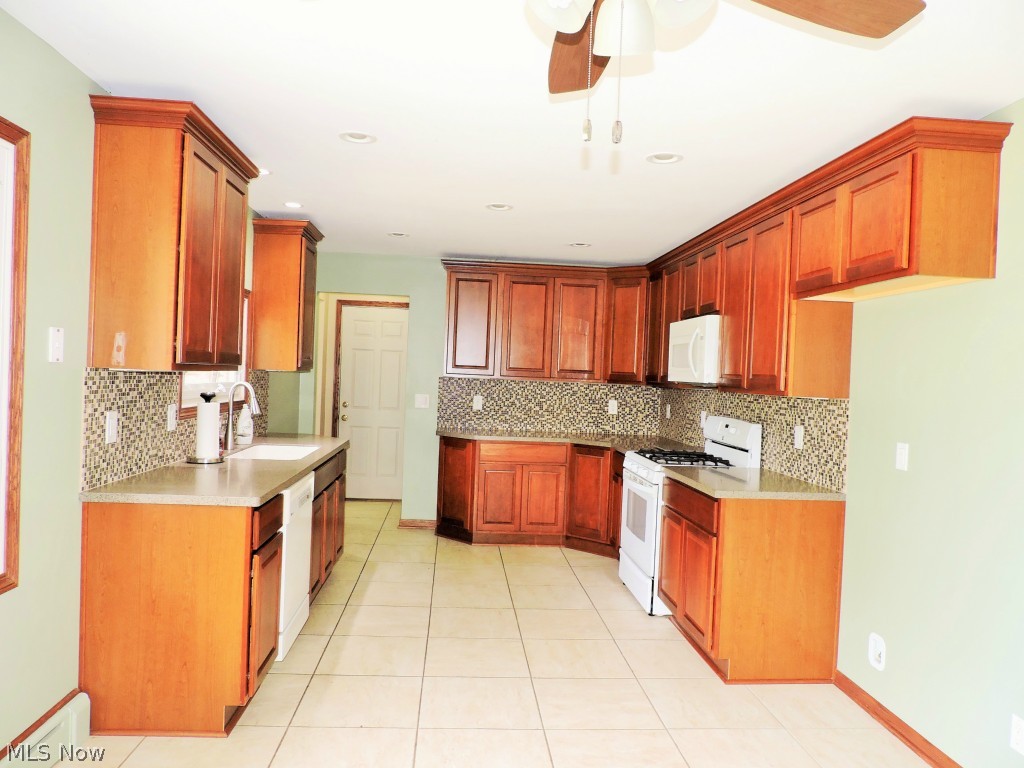 Eat-in kitchen with tile backsplash, soft close cabinets with roll outs & lazy susan, double deep sink and corian countertops