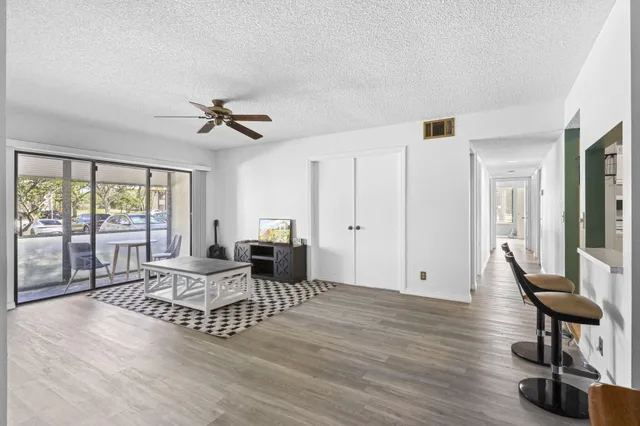 a living room with furniture floor to ceiling window and wooden floor