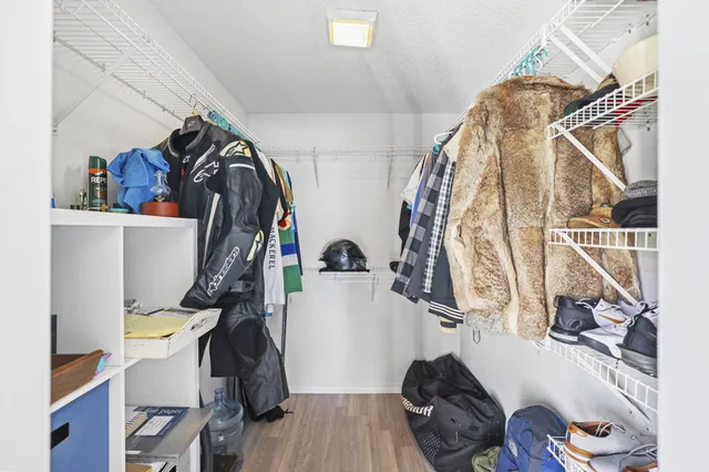 a view of walk in closet with clothes and shoes