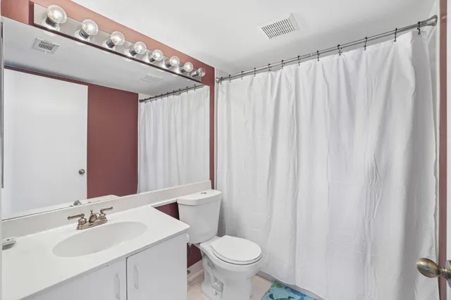 a bathroom with a toilet a sink and a mirror