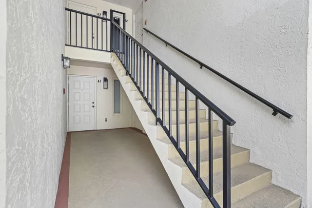 a view of staircase with wooden floor and white walls