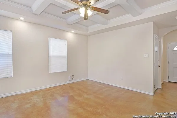 en empty room with ceiling fan and window