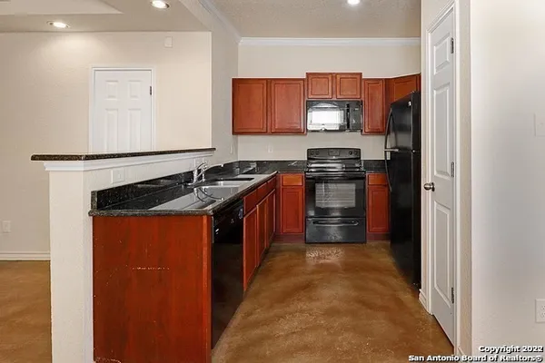 a kitchen with stainless steel appliances granite countertop a stove a sink and a refrigerator
