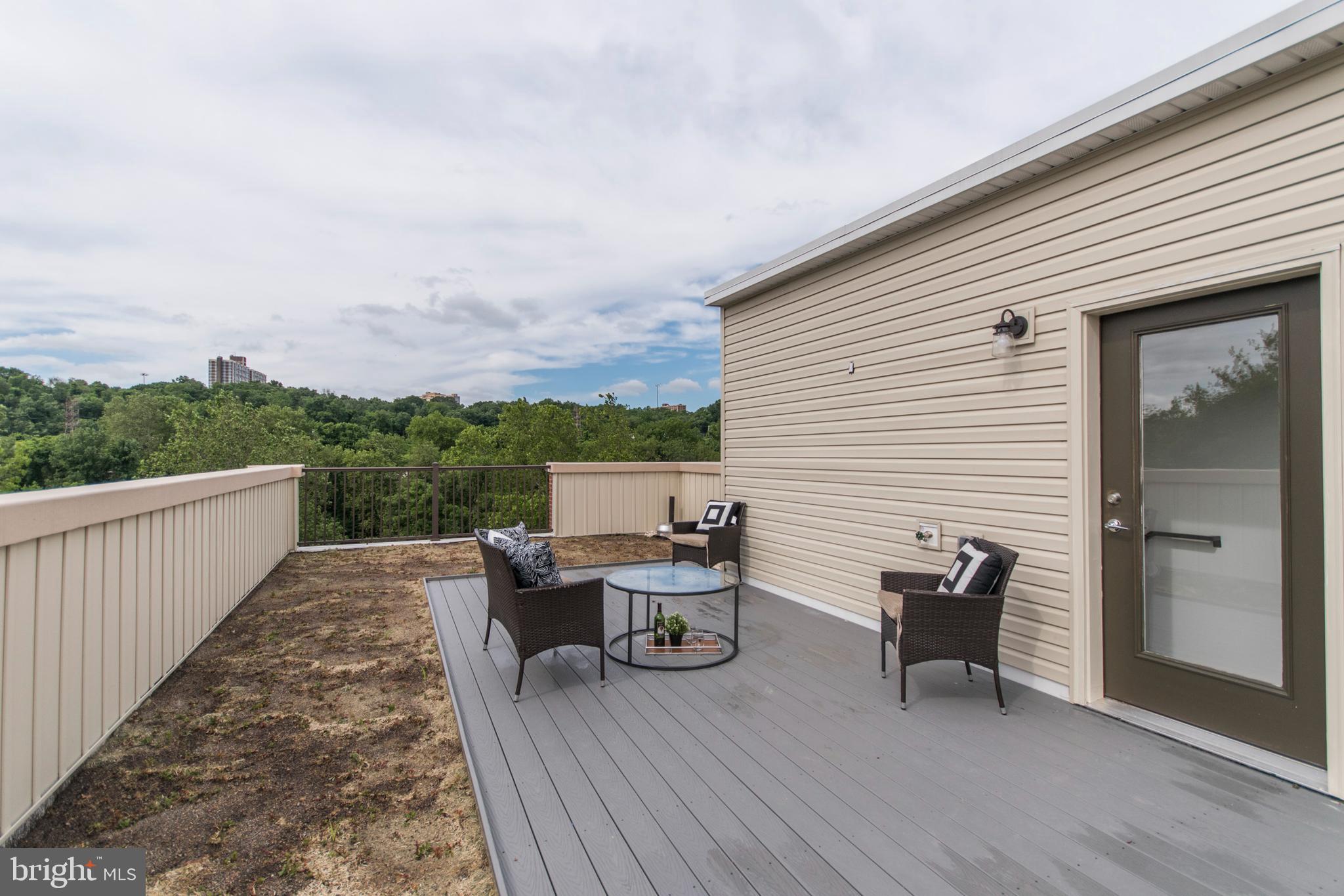 4443 River Ridge Court, Unit 13 Philadelphia, PA 19129 - Photo 33 of 35 a balcony with wooden floor table and chairs