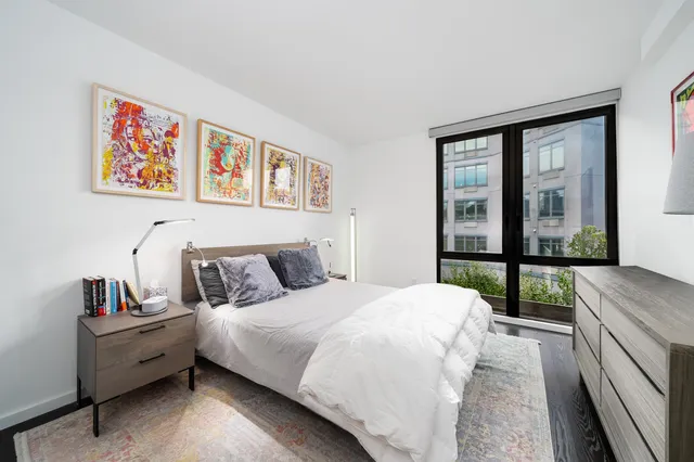 a bedroom with a bed and a large window