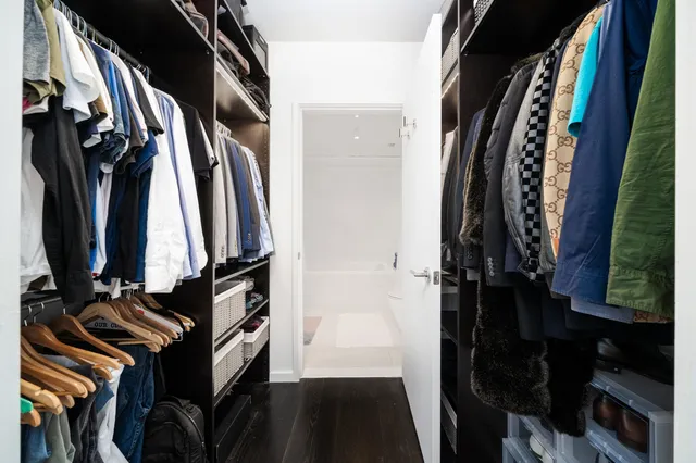 a view of walk in closet with clothes and shoes