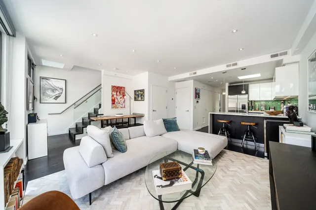 a living room with furniture kitchen view and a table