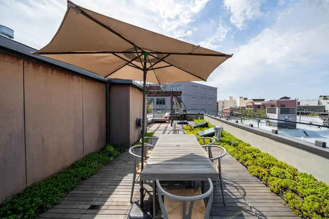 a view of a patio with table and chairs under an umbrella