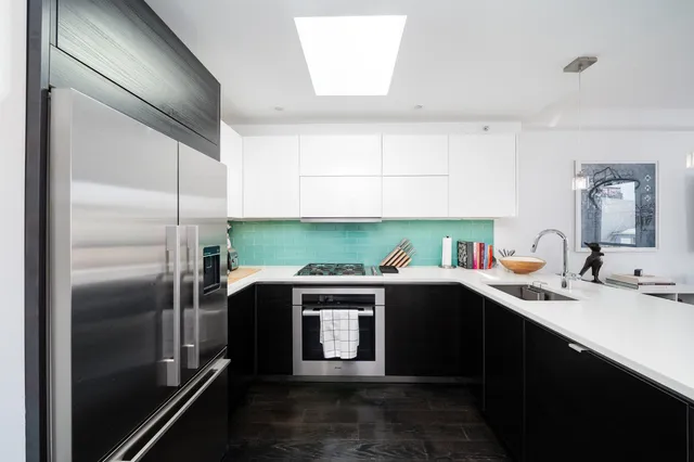 a kitchen with kitchen island a sink stove and refrigerator
