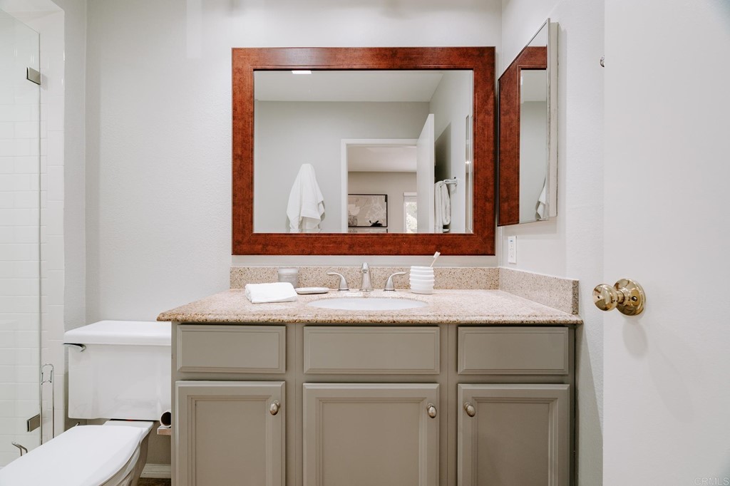 13754 Mango Drive, Unit 218 Del Mar, CA 92014 - Photo 20 of 31 a bathroom with a toilet sink and mirror