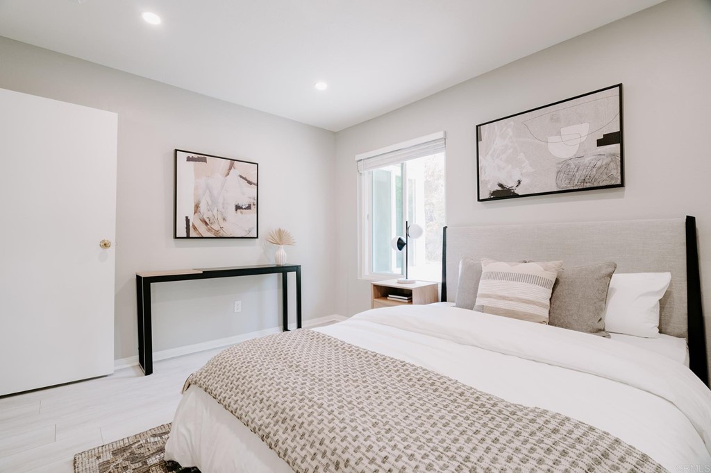 13754 Mango Drive, Unit 218 Del Mar, CA 92014 - Photo 22 of 31 a bedroom with a large bed and a painting on the wall