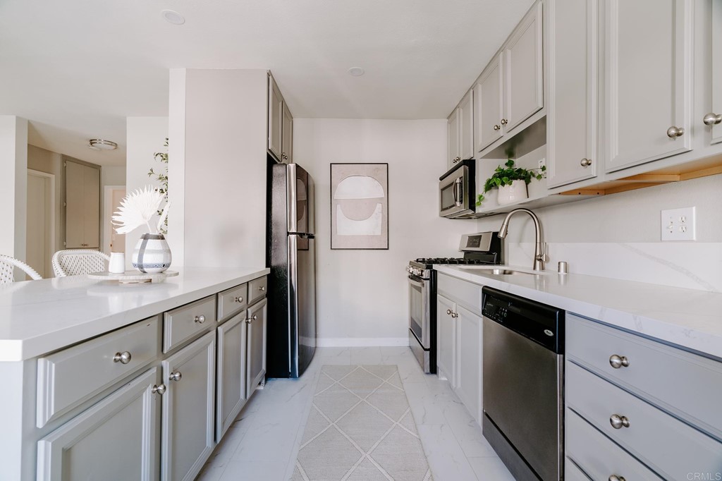 13754 Mango Drive, Unit 218 Del Mar, CA 92014 - Photo 8 of 31 a kitchen with stainless steel appliances granite countertop a refrigerator and a sink