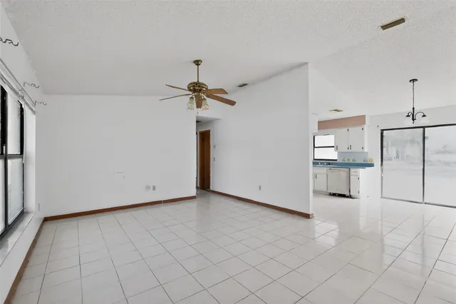 a view of a kitchen with a refrigerator and white cabinets