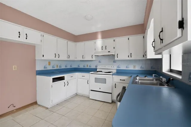 a kitchen with granite countertop white cabinets and white appliances