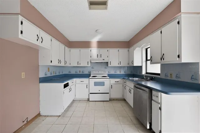 a kitchen with cabinets appliances a sink and a counter top