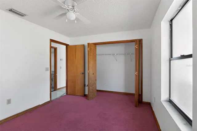 an empty room with chandelier fan