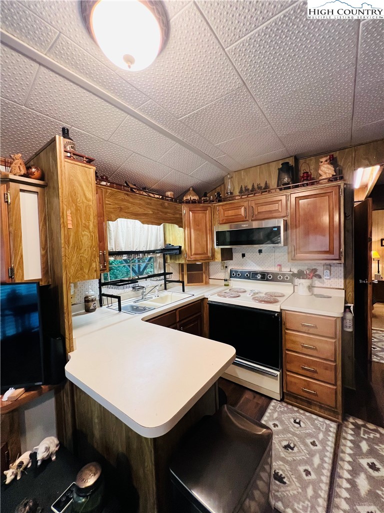 85 Jack Pine Loop Newland, NC 28657 - Photo 8 of 29 a kitchen with a sink a stove and chairs