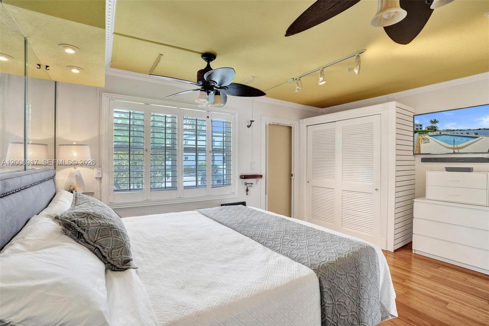 1105 South Riverside Drive, Unit 107 Pompano Beach, FL 33062 - Photo 4 of 31 a bedroom with a large bed and a chandelier