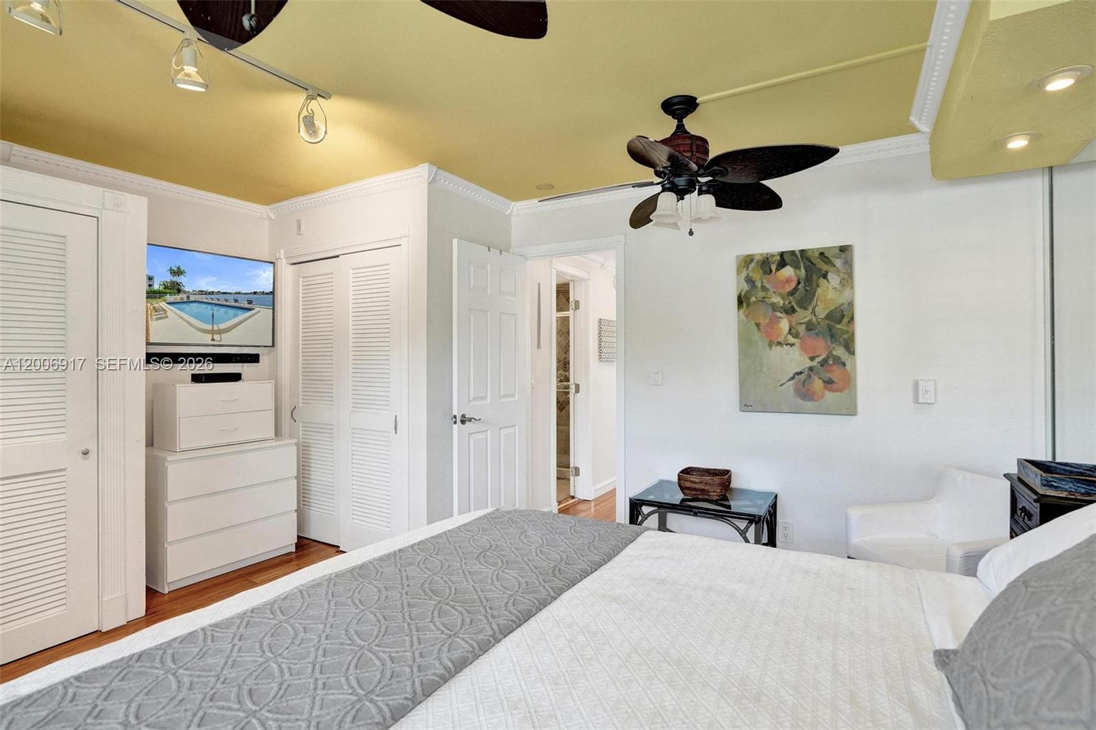 1105 South Riverside Drive, Unit 107 Pompano Beach, FL 33062 - Photo 5 of 31 a bedroom with a bed and a chandelier