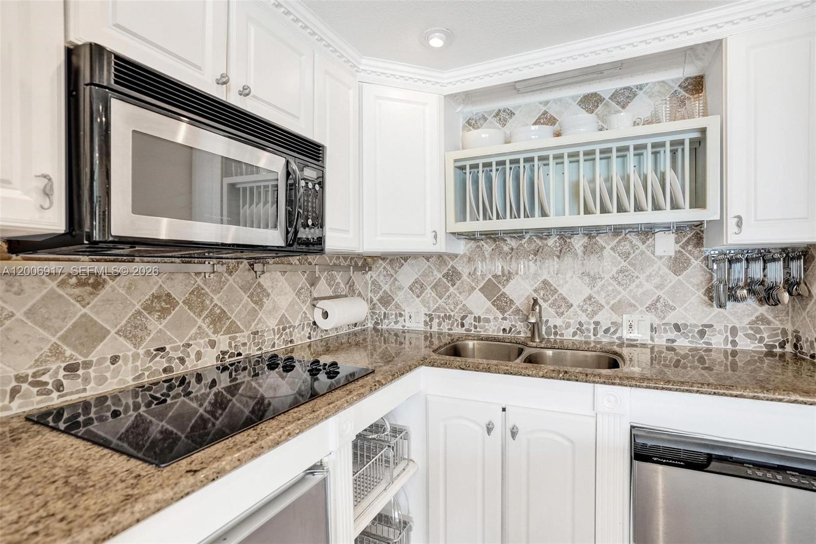 1105 South Riverside Drive, Unit 107 Pompano Beach, FL 33062 - Photo 9 of 31 a kitchen with stainless steel appliances granite countertop a sink and a stove