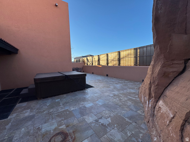 3439 Westwater Road Moab, UT 84532 - Photo 5 of 64 Fenced backyard featuring a hot tub and a large patio area
