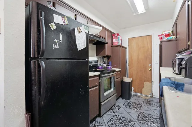 a kitchen with stainless steel appliances granite countertop a refrigerator and a sink