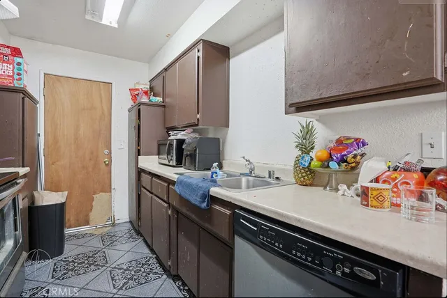 a kitchen with stainless steel appliances a sink dishwasher stove and cabinets