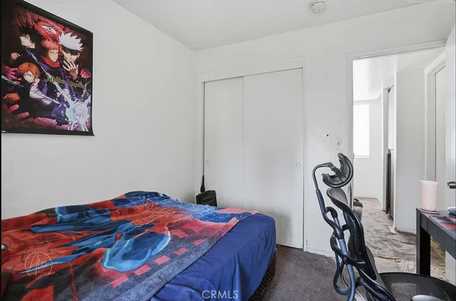 a bedroom with a bed and a painting on the wall