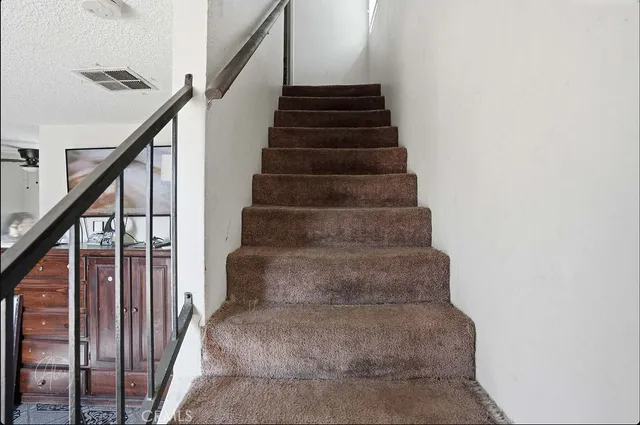 a view of staircase with wooden floor and white walls