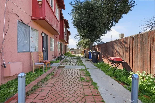 a view of a pathway that has a small yard plants and a chair