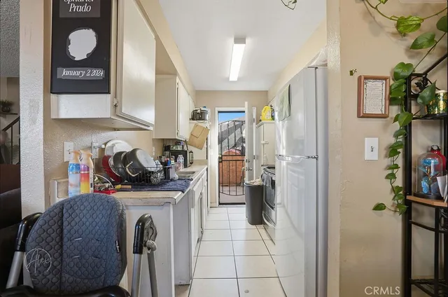 a view of a kitchen with fridge and workspace