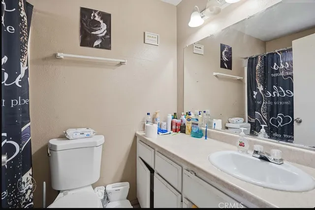 a bathroom with a sink toilet and a mirror