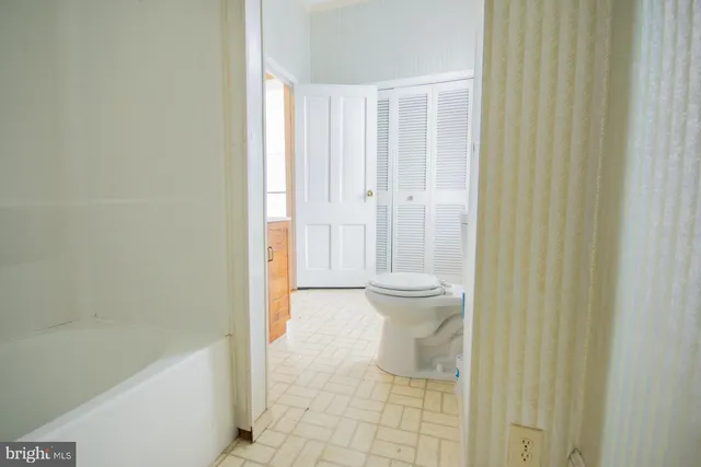a view of a big room with wooden floor and a kitchen