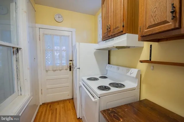 a white house that has a tree in front of it