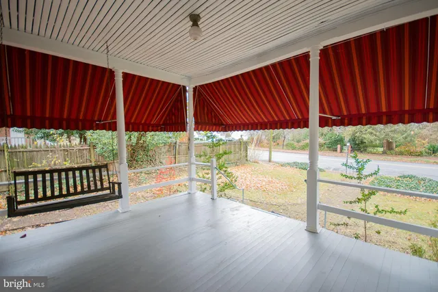 a view of a room with wooden floor fireplace and windows