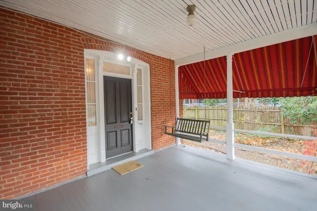 a view of a room with wooden floor fireplace and window