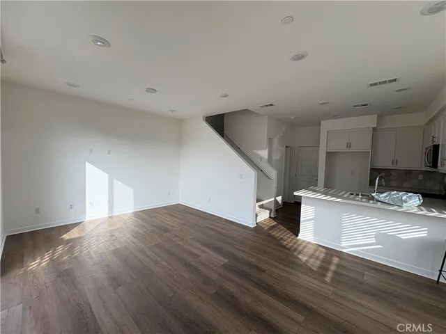 a kitchen with a sink a microwave a refrigerator and cabinets