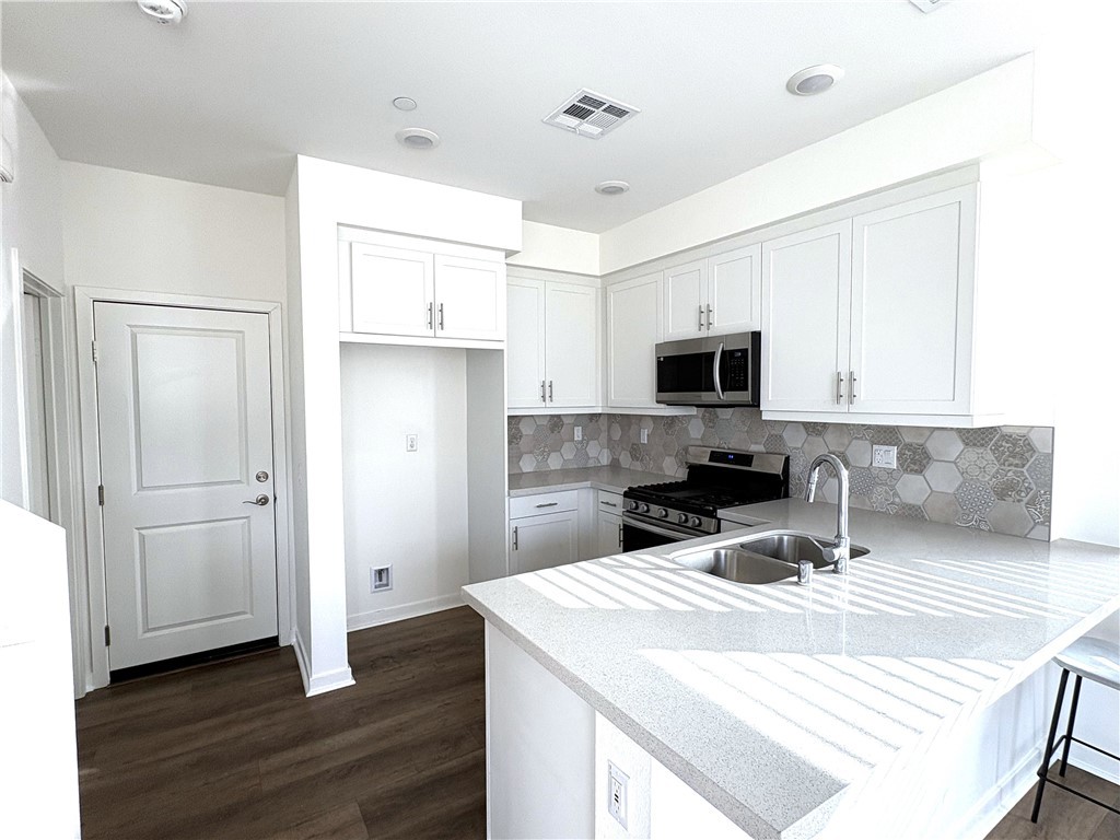 1368 Anise Way Upland, CA 91786 - Photo 5 of 20 a kitchen with a sink a microwave a refrigerator and cabinets