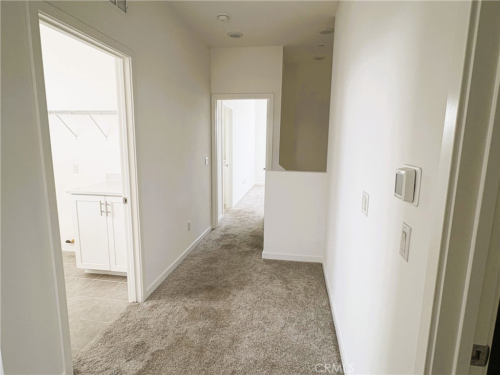 1368 Anise Way Upland, CA 91786 - Photo 8 of 20 a view of a hallway with wooden floor and a bathroom