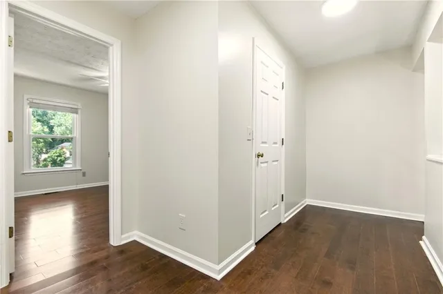 a view of a hallway with wooden floor and a window