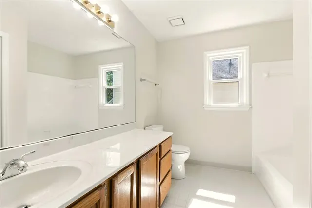 a bathroom with a sink a toilet and mirror