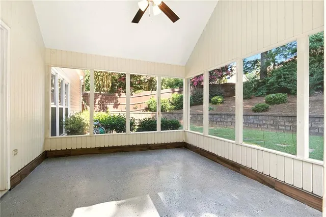 a view of swimming pool with lawn chairs and wooden fence