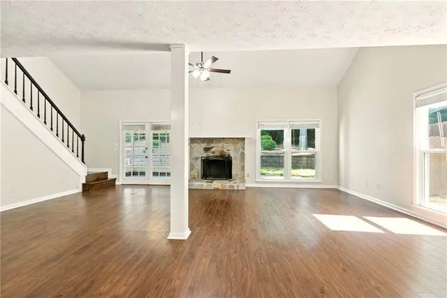 a view of empty room with wooden floor and fireplace