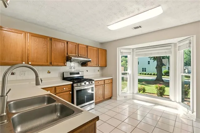 a kitchen with stainless steel appliances granite countertop a stove and a sink
