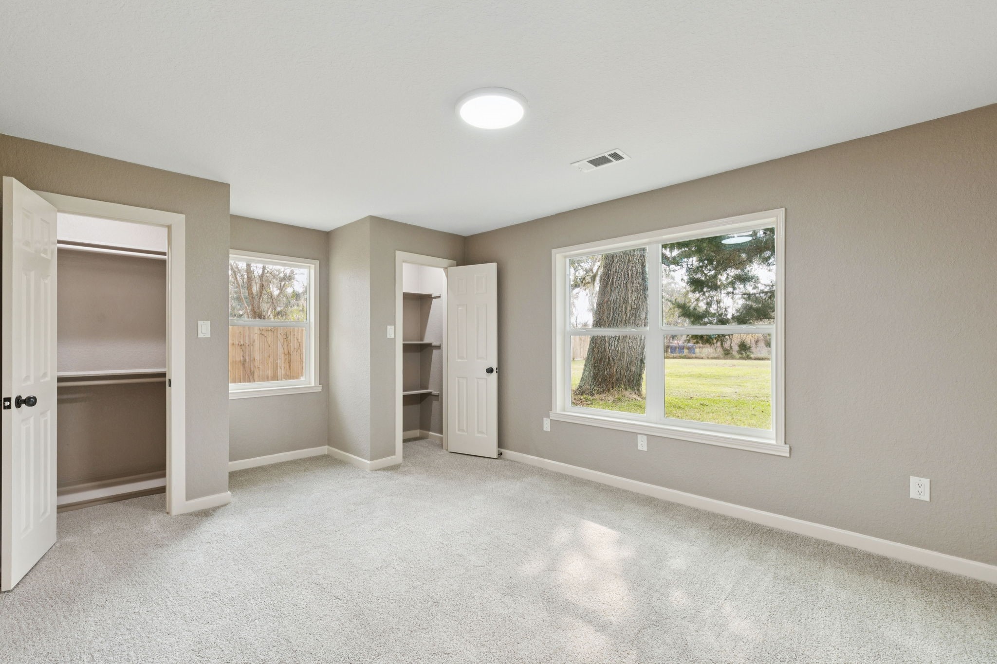 185 Hunters Lane Sweeny, TX 77480 - Photo 12 of 22 a view of an empty room with a window and a kitchen