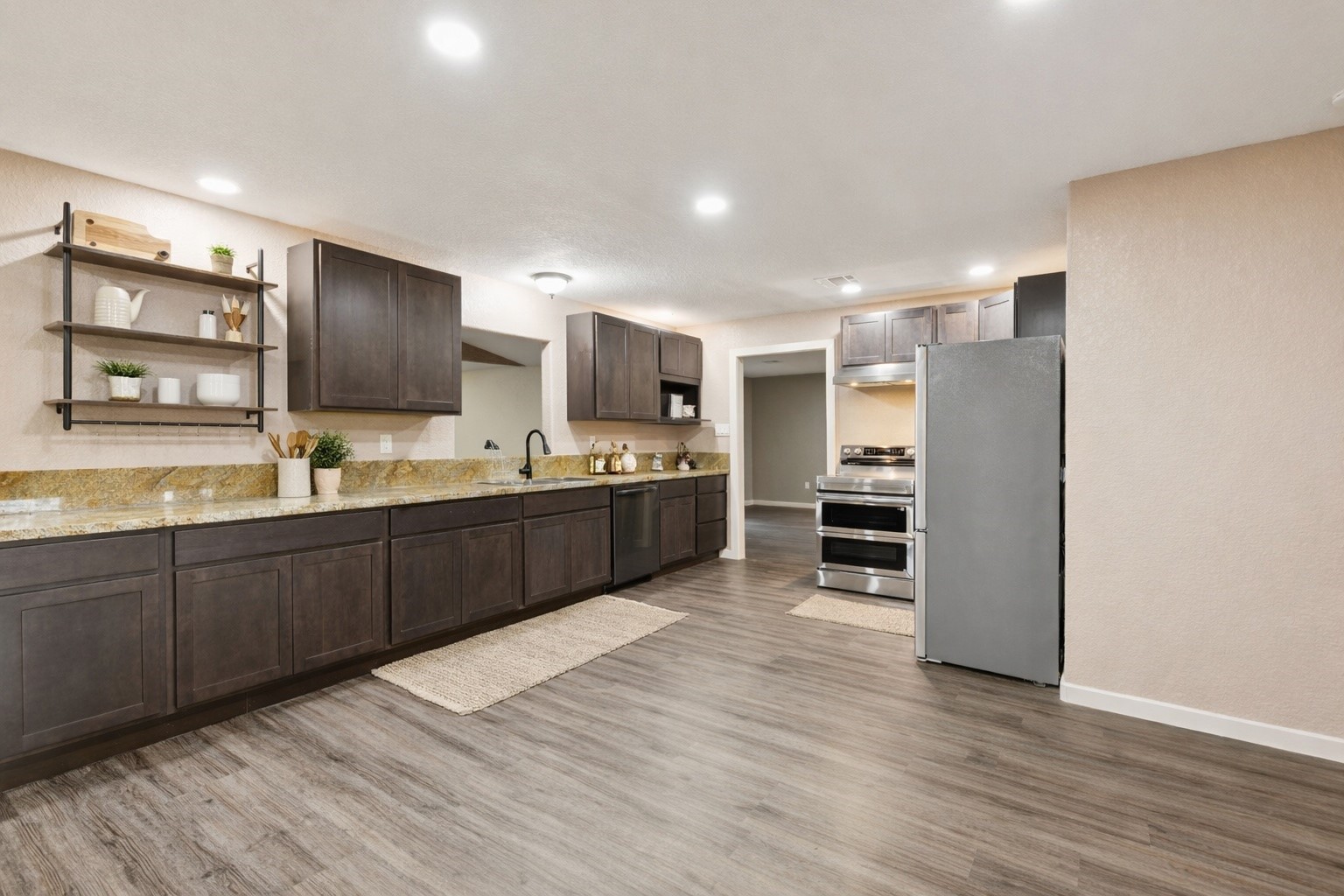 185 Hunters Lane Sweeny, TX 77480 - Photo 3 of 22 a large kitchen with wooden floors and stainless steel appliances