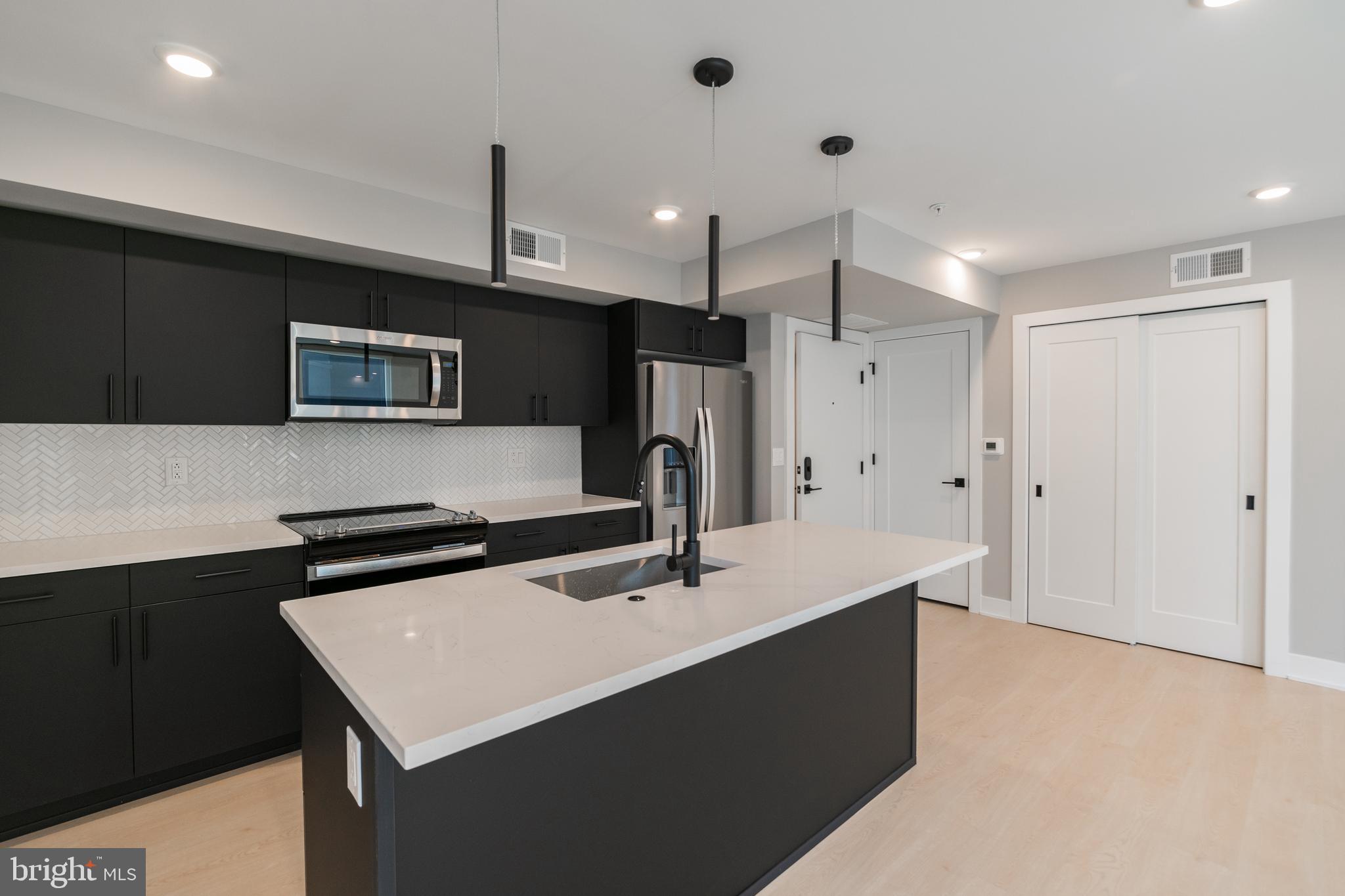 a kitchen with stainless steel appliances a sink a refrigerator and a stove