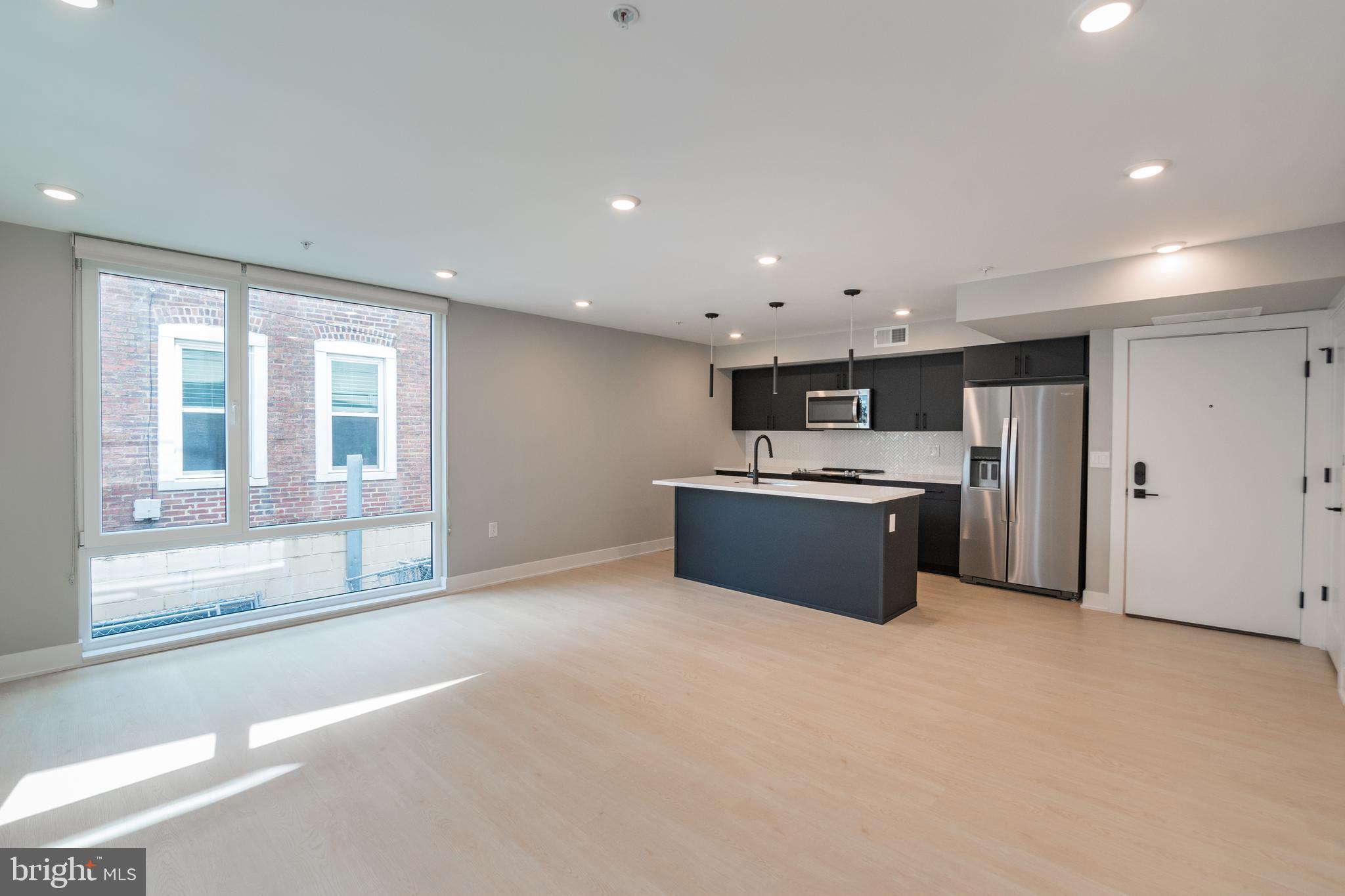 6604 Ridge Avenue, Unit 401 Philadelphia, PA 19128 - Photo 4 of 11 a large kitchen with a stove a sink and a refrigerator