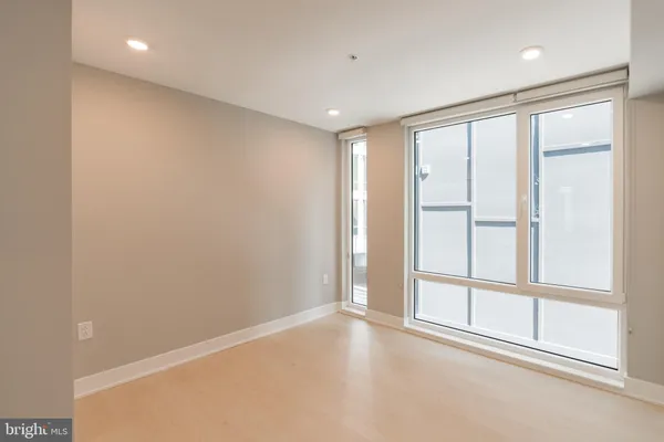 an empty room with windows and closet